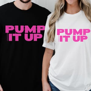 May include: Two t-shirts with the text "Pump It Up" in pink letters on a black and white background.