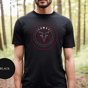male witch in woods wearing black goth Satanic witch shirt that features Baphomet, moon phases, magical circles, and a pentagram for the ultimate gift for a witch or a fan of witch horror.