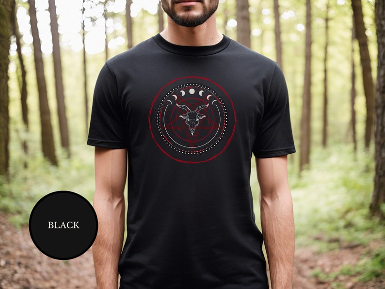 male witch in woods wearing black goth Satanic witch shirt that features Baphomet, moon phases, magical circles, and a pentagram for the ultimate gift for a witch or a fan of witch horror.