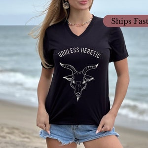 May include: Black v-neck t-shirt with the text "Godless Heretic" and a white line drawing of a goat's head.
