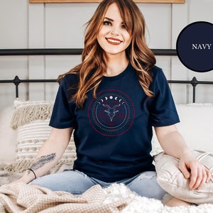 Wiccan witch wearing blue goth Satanic witch shirt that features Baphomet, moon phases, magical circles, and a pentagram for the ultimate gift for a witch or a fan of witch horror.