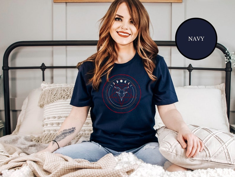 Wiccan witch wearing blue goth Satanic witch shirt that features Baphomet, moon phases, magical circles, and a pentagram for the ultimate gift for a witch or a fan of witch horror.