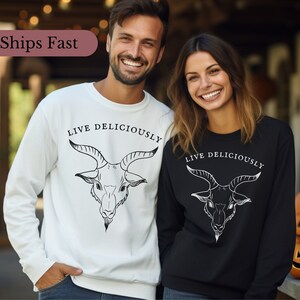 male and female witches wearing a witchcraft Black Phillip sweatshirt that reads Live Deliciously and features a demonic Baphomet goat head on the front
