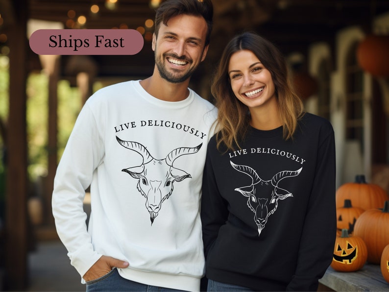 male and female witches wearing a witchcraft Black Phillip sweatshirt that reads Live Deliciously and features a demonic Baphomet goat head on the front