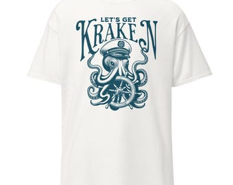 May include: White t-shirt featuring a navy blue illustration of an octopus wearing a captain's hat and holding a ship's wheel. The text "LET'S GET KRAKEN" is arched above the octopus design.