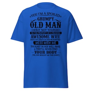 May include: Royal blue t-shirt with black text. The text reads "YES! I'M A SPOILED GRUMPY OLD MAN BUT NOT YOURS... I'M THE PROPERTY OF A FREAKING AWESOME WIFE... MESS WITH ME... YOUR BODY... (YES, SHE BOUGHT ME THIS SHIRT)".