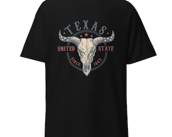 May include: Black t-shirt featuring a graphic of a bull skull with the text "TEXAS UNITED STATE SINCE 1845" in a circular design. The design includes stars and a rope-like border, creating a vintage aesthetic.