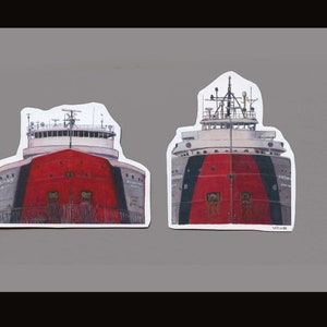 May include: Two illustrations of red, white and black ships. The ships are facing forward and have a large red section in the middle. The ships are on a grey background.