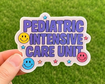 May include: A sticker with the words "PEDIATRIC INTENSIVE CARE UNIT" in purple block letters. The sticker has a light pink background and is decorated with smiley faces and stars. The sticker is held by a hand against a green background.
