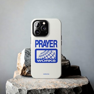 May include: White iPhone case with a blue logo that says "PRAYER WORKS" and a globe graphic.