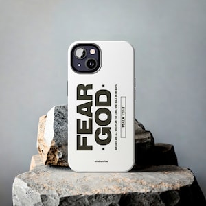 May include: White iPhone case with the words "FEAR GOD" in bold, dark letters, with a star on each side. The case also includes the text "BLESSED ARE ALL WHO FEAR THE LORD, WHO WALK IN HIS WAYS. PSALM 128:1".