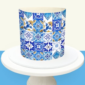 Puede incluir: Un pastel decorado con un patrón de azulejos azules y blancos, que recuerda a los azulejos portugueses tradicionales. El pastel está sobre un soporte blanco para pasteles sobre un fondo claro.