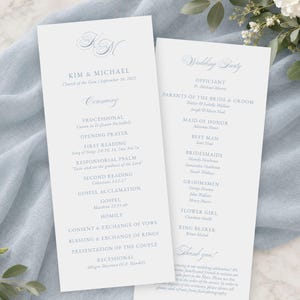 May include: Two white wedding program cards with light blue text. The left card features the names Kim & Michael, the date, and the ceremony order. The right card lists the wedding party members, including the officiant, parents, and attendants.