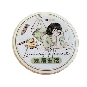 May include: Round sticker with an illustration of a person lying down, wearing glasses and a green shirt. The sticker has the text "Living Alone" and Chinese characters. A tube of cream and a pastry are also depicted.