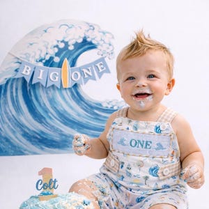 the big one first birthday boy romper my first wave summer beach surfer aqua blue tan white gingham yellow smash cake outfit overalls, ONE smocked romper first birthday beach party surfing, ocean embroidered smocked spring summer 1st birthday boy outfit romper baby boys cake smash outfit, the mod mango baby boutique co
