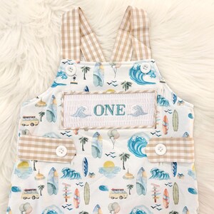 the big one first birthday boy romper my first wave summer beach surfer aqua blue tan white gingham yellow smash cake outfit overalls, ONE smocked romper first birthday beach party surfing, ocean embroidered smocked spring summer 1st birthday boy outfit romper baby boys