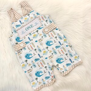the big one first birthday boy romper my first wave summer beach surfer aqua blue tan white gingham yellow smash cake outfit overalls, ONE smocked romper first birthday beach party surfing, ocean embroidered smocked spring summer 1st birthday boy outfit romper baby boys