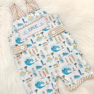 the big one first birthday boy romper my first wave summer beach surfer aqua blue tan white gingham yellow smash cake outfit overalls, ONE smocked romper first birthday beach party surfing, ocean embroidered smocked spring summer 1st birthday boy outfit romper baby boys