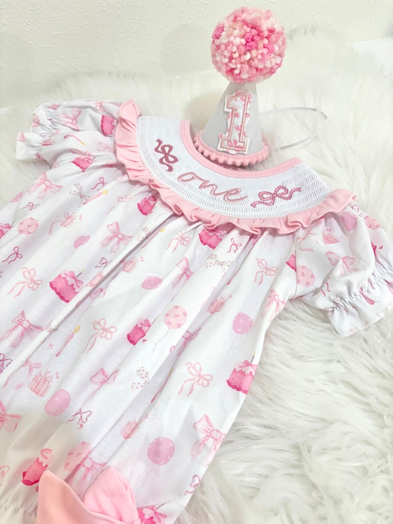 pink bow first birthday girl romper pink and white outfit, pink white smocked bubble romper first birthday winter bows ruffle bows  embroidered smocked long sleeve 1st birthday outfit romper baby girls the mod mango baby boutique