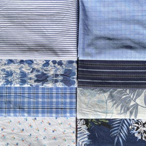 May include: A collection of eight fabric swatches arranged in a grid. Patterns include blue and white horizontal stripes, a light blue grid, a blue abstract print, dark blue horizontal stripes, a blue plaid, a white palm leaf print, a white floral print, and a dark blue tropical floral pattern.