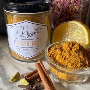Op de afbeelding: Een glazen pot gevuld met kurkumapoeder met het label "Mystic Tea Company Turmeric Adaptogenic Powder" met de tekst "Enjoy add to hot milk, nut milk alternatives or hot water and a variety of teas. 4 oz | 118 ml".