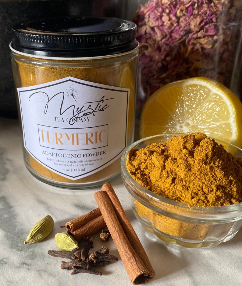 Op de afbeelding: Een glazen pot gevuld met kurkumapoeder met het label "Mystic Tea Company Turmeric Adaptogenic Powder" met de tekst "Enjoy add to hot milk, nut milk alternatives or hot water and a variety of teas. 4 oz | 118 ml".