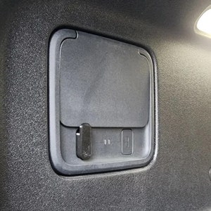 May include: A black plastic compartment with a small latch and a button labeled "H".