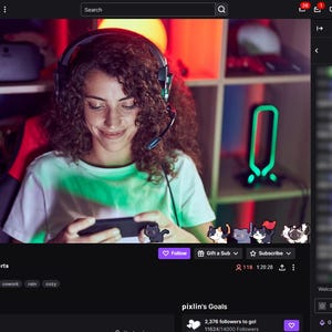 Pode incluir: Uma captura de tela de uma transmiss&atilde;o do Twitch com uma pessoa usando fones de ouvido e jogando em um dispositivo m&oacute;vel. A transmiss&atilde;o &eacute; intitulada "pixlin" e inclui informa&ccedil;&otilde;es de bate-papo e seguidores. O fundo &eacute; uma sala com prateleiras e uma luz de n&eacute;on.