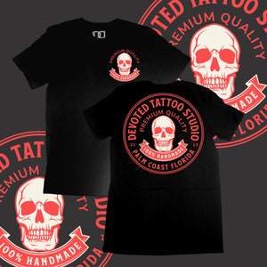 May include: Black t-shirt with a red circle graphic featuring a skull and the text "Devoted Tattoo Studio", "Premium Quality", "100% Handmade", "2013", "Palm Coast Florida".