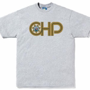 Op de afbeelding: Een grijs T-shirt met een gouden en blauwe grafische afbeelding van de letters "CHP" met een ster en een schild.