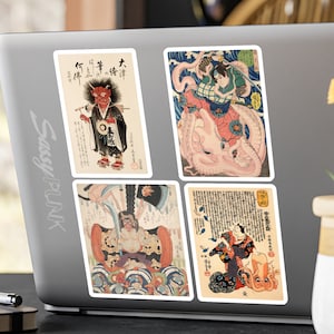 May include: Four vintage Japanese woodblock prints featuring colorful illustrations of mythical creatures and figures. The prints are framed with white borders and have Japanese text.