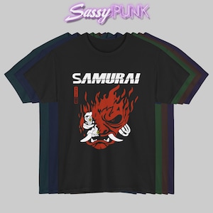 May include: Black t-shirt featuring the word "SAMURAI!" in white block letters above a red graphic of a flaming demon face. The t-shirt design includes Japanese text and a white skull-like figure. The brand name "Sassy Punk" is at the top.