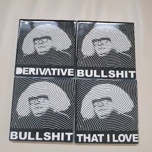 May include: Four black square coasters with a white and black circular pattern. The coasters have the text "DERIVATIVE BULLSHIT" and "BULLSHIT THAT I LOVE" printed in white.