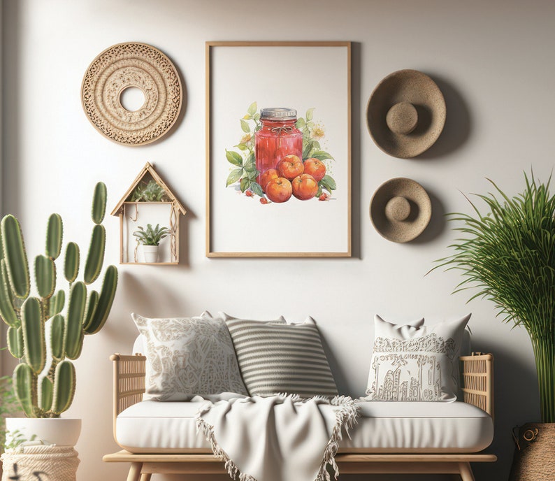 May include: A watercolor painting of a jar of jam with red berries and a few green leaves. The painting is framed and hanging on a white wall above a white couch with pillows and a throw blanket. There are two woven wall hangings and a small wooden shelf with a potted plant on the wall.