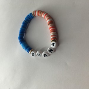 May include: A blue and orange beaded bracelet with the word "OHANA" spelled out in white beads.