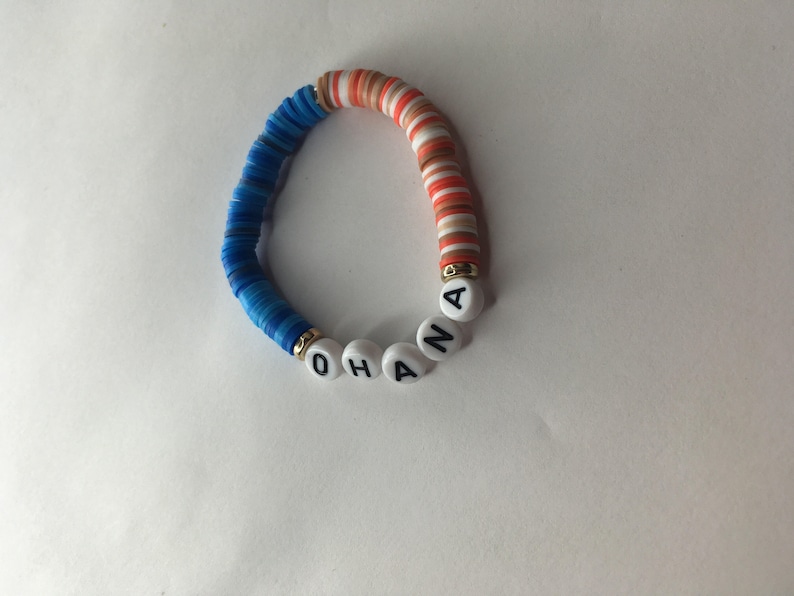May include: A blue and orange beaded bracelet with the word "OHANA" spelled out in white beads.