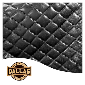 Op de afbeelding: Zwart leermateriaal met een gewatteerd ruitpatroon. Het leer heeft een glanzende afwerking en is gestikt met zwart garen. Het logo van Dallas Leather Co. staat in de linker benedenhoek.