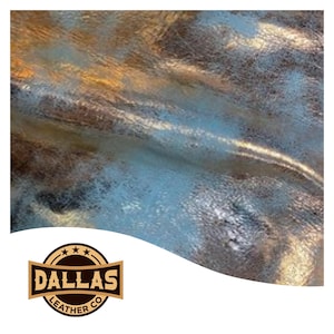 May include: Close-up of metallic leather with a textured surface. The leather has a mix of colors, including gold, silver, and blue. The Dallas Leather Co. logo is in the bottom left corner.