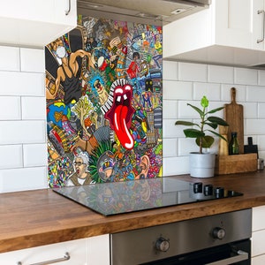 May include: A colourful kitchen splashback with a pop art collage design. The artwork features musical instruments, a red tongue, and cartoon figures. The splashback is installed behind a black hob.