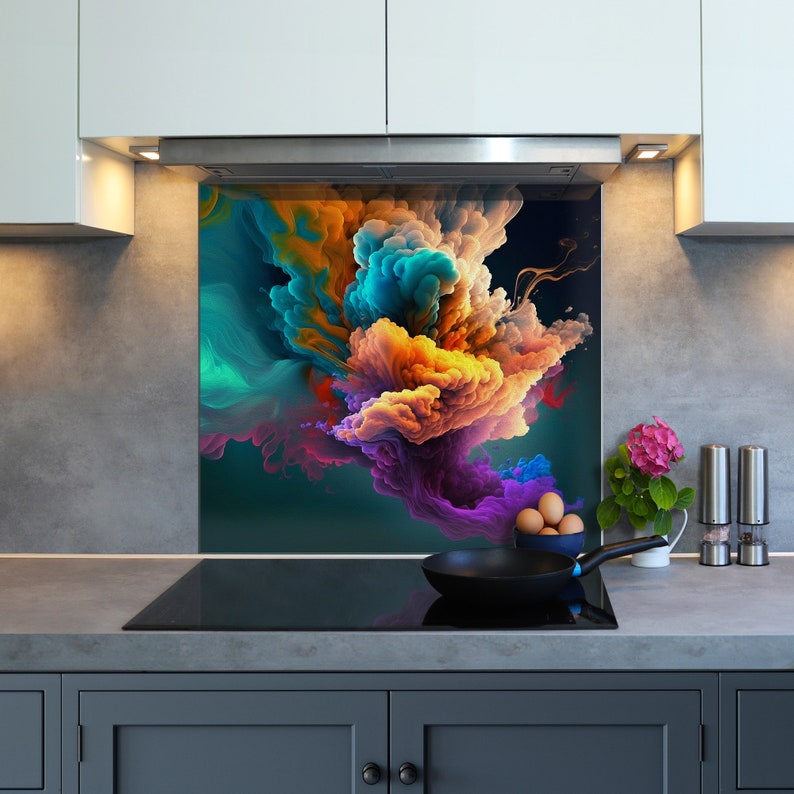 May include: A colorful abstract kitchen backsplash with a design of swirling clouds of blue, orange, purple, and green. The backsplash is installed above a black stovetop with a black frying pan and eggs on the counter.