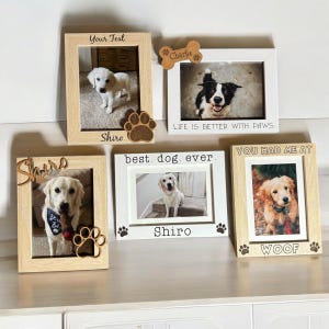 May include: A collection of framed dog photos. The frames are in various styles, including light wood and white, with paw print and bone accents. Text includes "Your Text", "Charlie", "LIFE IS BETTER WITH PAWS", "best. dog. ever.", "YOU HAD ME AT WOOF", and "Shiro".