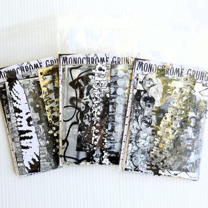 May include: Three clear plastic sleeves containing paper ephemera labeled Monochrome Grunge. The contents feature black, white, and metallic gold abstract patterns, including splatters, geometric shapes, and textured layers of printed designs.