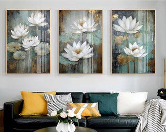 Könnte beinhalten: Drei gerahmte Leinwanddrucke mit weißem Hintergrund und goldenen Akzenten. Jeder Druck zeigt eine stilisierte Malerei von weißen Lotusblumen mit grünen Blättern.