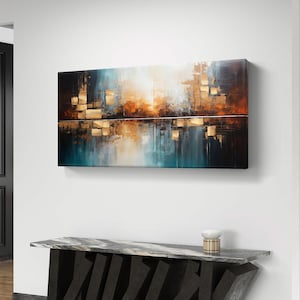 Puede incluir: Pintura abstracta de paisaje con tonos turquesa, naranja y dorado. La obra de arte está colgada en una pared blanca sobre una consola moderna con tapa de mármol y base geométrica negra. Una pequeña lámpara decorativa está sobre la mesa.