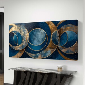 Pode incluir: Arte de parede abstrata com círculos sobrepostos em tons de azul e dourado. Os círculos são delineados em dourado e têm um efeito texturizado de pinceladas.