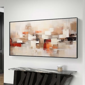 Op de afbeelding: Abstract schilderij in tinten beige, bruin en rood met een zwarte lijst die hangt boven een zwarte marmeren consoletafel met een geometrisch ontwerp.