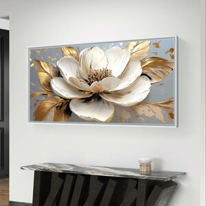 Peut inclure: Une impression sur toile repr&eacute;sentant une fleur blanche avec des accents dor&eacute;s. La fleur est de style 3D, avec des p&eacute;tales et des feuilles en relief.