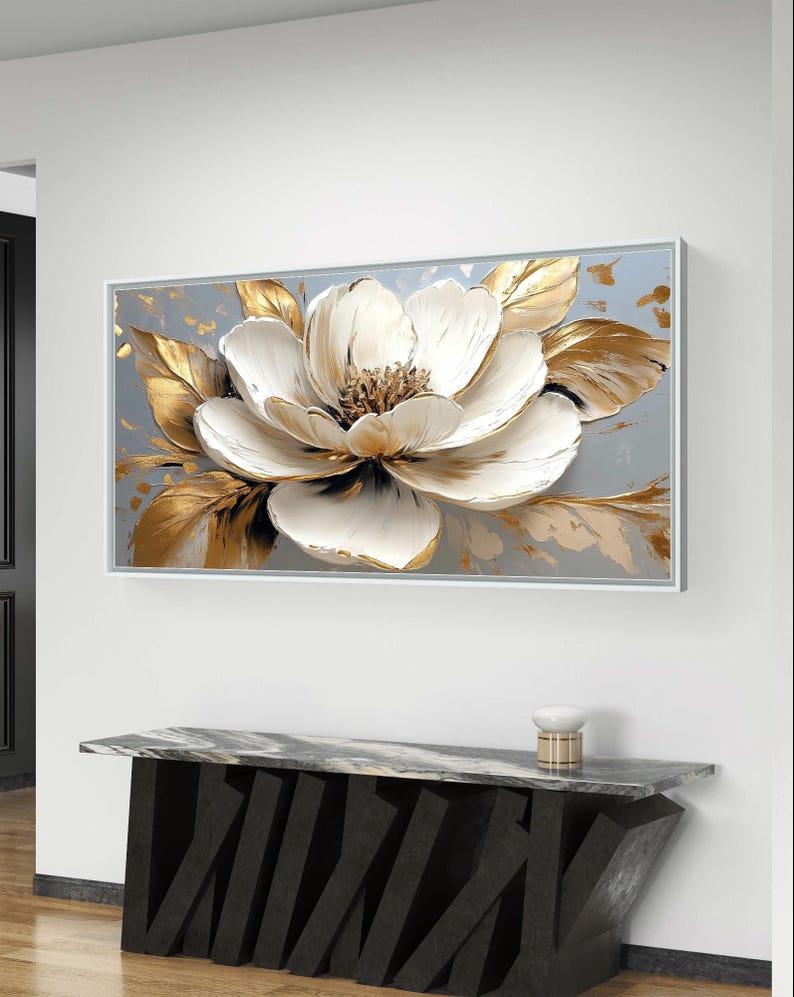 Peut inclure: Une impression sur toile repr&eacute;sentant une fleur blanche avec des accents dor&eacute;s. La fleur est de style 3D, avec des p&eacute;tales et des feuilles en relief.