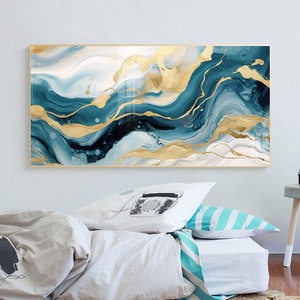 May include: Abstract wall art print featuring swirling blue and gold paint with a white background. The print is framed in a thin gold frame.