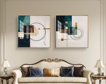 May include: Two framed abstract art pieces with gold frames. Each features geometric shapes in teal, brown, and gold against a white background. A sofa with decorative pillows and two lamps flank the artwork.